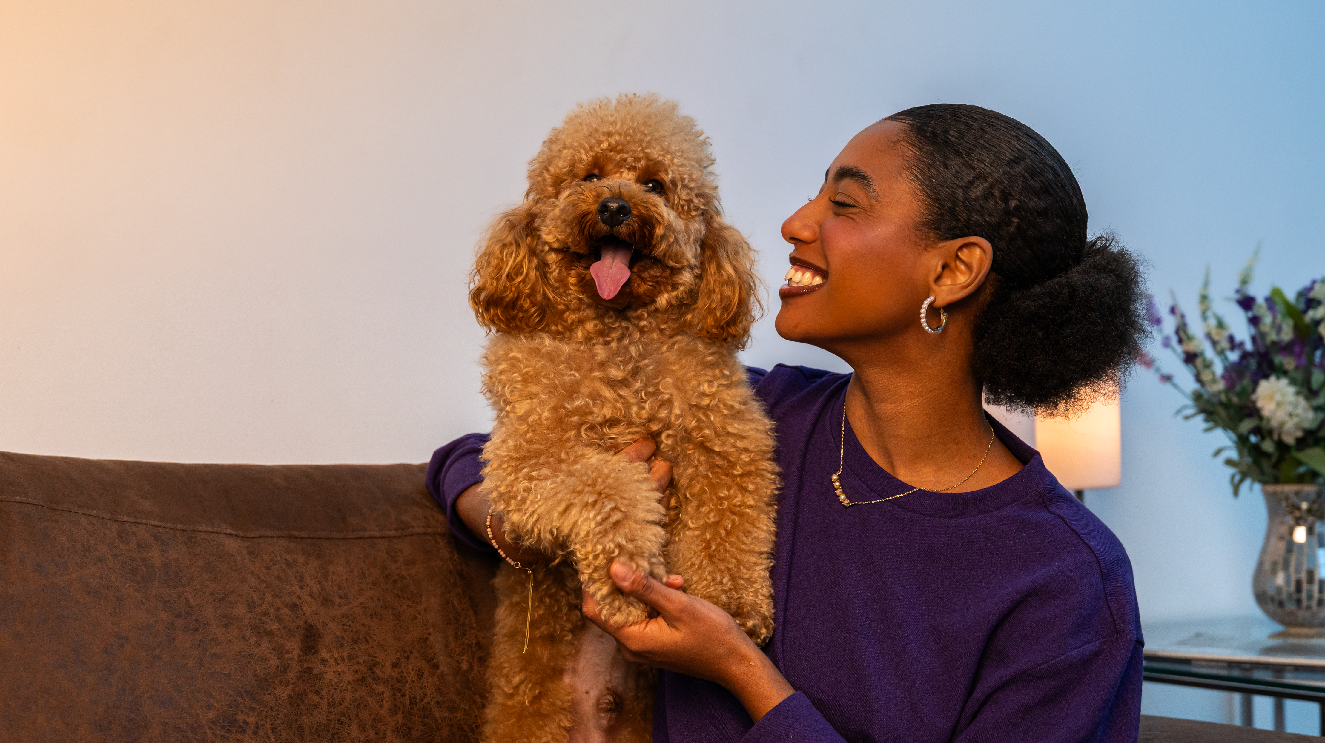 Colaboradora sorrindo com seu cachorro poodle